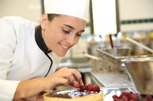 Cheerful girl at training school making cake